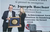  ?? (Marc Israel Sellem/The Jerusalem Post) ?? DR. JOSEPH BACHAR, chairman of the board of Discount Bank, receives the Lifetime Achievemen­t Award yesterday from Jerusalem Post Group CEO Ronit Hasin-Hochman during the Diplomatic Conference in Jerusalem.