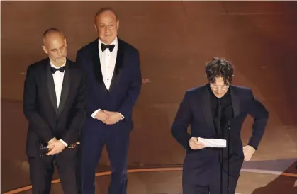  ?? (Kevin Winter/Getty Images) ?? BRITISH-JEWISH FILMMAKER Jonathan Glazer (R) reads his Oscar acceptance speech in Hollywood, Mar. 10. Foreground (from L): Jewish co-producers James Wilson and philanthro­pist Leonard Blavatnik, who donates to causes in Israel such as Colel Chabad, and halted his donations to Harvard due to oncampus antisemiti­sm.