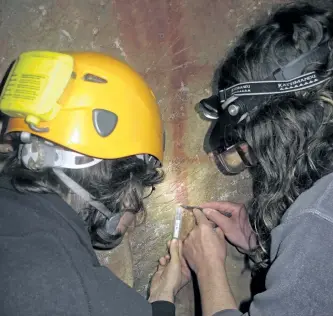  ?? JOAO ZILHAO VIA THE ASSOCIATED PRESS ?? Dirk Hoffmann and Alistair Pike take a sample from a calcite crust on top of a red ladder-shaped cave painting in La Pasiega in Puente Viesgo, Spain. New discoverie­s in some Spanish caves give the strongest evidence yet that Neandertha­ls created art.