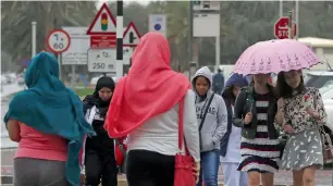  ?? — Photo by Ryan Lim ?? Hoodies and umbrellas were out as Abu Dhabi residents welcomed a rainy morning.