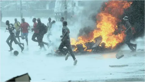  ??  ?? PEOPLE flee as barricades burn during protests in Harare, Zimbabwe, yesterday. | PHILIMON BULAWAYO Reuters