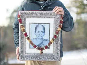  ?? RICHARD LAUTENS TORONTO STAR ?? Josh Suresh holds a photo of his mother who had dementia and reverted to only speaking her first language, Tamil, and had stopped eating and talking before she died in 2019.