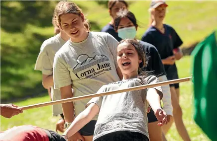  ?? AIMAN AMERUL MUNER/STUFF ?? Grace McClelland, 14, of Timaru Girls’ High School, does a limbo challenge during the Caroline Bay amazing race.
