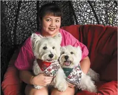  ??  ?? er with her pet white terriers Sasha and piper (right) at her home in Singapore. er stumbled into the pet influencer business several years ago when she started posting photos of Sasha in various costumes, playing with toys and on outings. — photos: afp