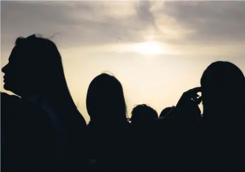  ??  ?? DECENAS de personas llegaron hasta San Juan para presenciar el evento, algunos de ellos con gafas o “tarjetas” especiales (derecha) para proteger la vista. Arriba a la derecha, Venus se observa como un pequeño punto sobre la esfera solar.