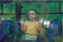  ?? AP PHOTO/BAZ RATNER ?? A young girl looks through a bus window Friday as her family departs the northern Israeli city of Kiryat Shmona, Israel.