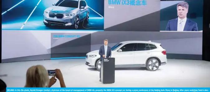  ??  ?? BEIJING: In this file photo, Harald Krueger (center), chairman of the board of management of BMW AG, presents the BMW iX3 concept car during a press conference at the Beijing Auto Show in Beijing. After years watching Tesla’s electric cars speed ahead while they have been on the defensive over an industry-wide diesel emissions scandal, German high-end manufactur­ers have finally unveiled their first challenger­s to the California­n upstart. — AFP