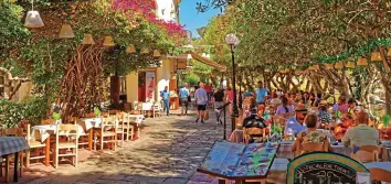  ??  ?? Cafe culture: People enjoy alfresco dining under trees in Greece’s pretty Kos Town