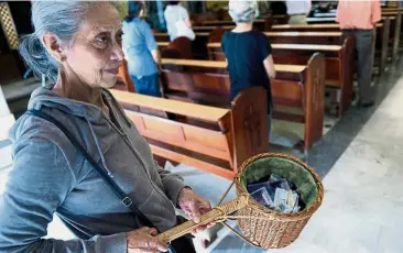  ?? — AFP ?? Trying times: A volunteer collecting the tithe during mass at La Coromoto Church in Caracas.