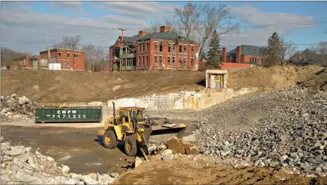  ?? TIM COOK/THE DAY ?? A bucket loader piles stone and concrete at the footprint of the former laundry facility and power house at the Norwich Hospital property in February as part of the cleanup of the property. members of the Preston Redevelopm­ent Agency tour the attic of...