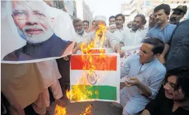  ?? Photo / AP ?? Pakistanis in Peshawar protest over New Delhi’s decision by burning an image of Indian Prime Minister Narendra Modi and an Indian flag.