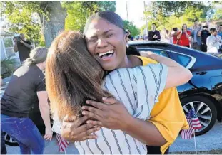  ?? JOE BURBANK/ORLANDO SENTINEL ?? Army veteran Nikita Wilson hugs Bank of America Senior Vice President Marisa Carnevale-Henderson as Wilson visits her new home in Pine Hills. The fully furnished three-bedroom home was donated to Wilson mortgage-free by the Veterans Associatio­n of Real Estate Profession­als in partnershi­p with the bank.