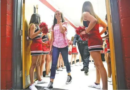  ?? STAFF PHOTOS BY ERIN O. SMITH ?? Trula Robinette reacts Monday as she walks into the gym full of her cheering classmates at Lakeview Middle School in Rossville, Ga. Robinette was one of two Lakeview Middle School students selected as REACH recipients.