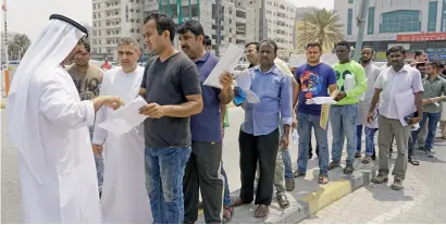  ?? Photo by M. Sajjad ?? A GDRFA official helps amnesty-seekers outside the Sharjah immigratio­n centre on Wednesday. —