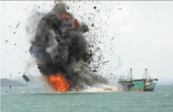  ?? M. Urip / Associated Press 2016 ?? Debris flies into the air as foreign fishing boats are blown up by the Indonesian Navy off Batam Island last year. The detonation­s are part of a government crackdown on illegal fishing.