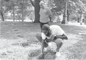  ?? YVONNE WENGER/BALTIMORE SUN ?? Handsome Lollar and his aunt Cindy Lollar-Owens visit the grave of Handsome’s brother, Richard, who was killed in 2000 after an altercatio­n with Ray Lewis and some friends.