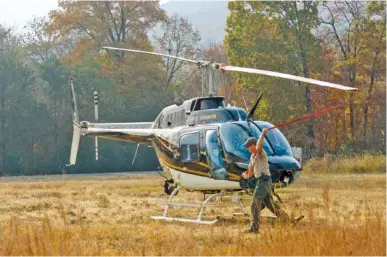  ?? STAFF FILE PHOTO ?? Tennessee Highway Patrol pilot Sgt. Lee Russell secures a THP helicopter’s rotor near a firefighti­ng staging area in 2016 when wildfires had broken out across the region. Russell and Marion County Sheriff’s Office Detective Matt Blansett were killed Aug. 23 when this same helicopter went down on the slopes of Aetna Mountain, 20-25 miles southwest of this scene in Soddy-Daisy.