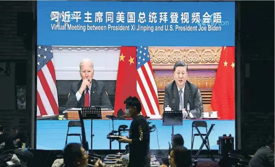  ?? TINGSHU WANG / REUTERS ?? Imatges de la trobada virtual entre Biden i Xi projectade­s en una pantalla en un restaurant de Pequín