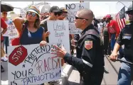  ?? AP/ANDRES LEIGHTON ?? A police officer tries to remove anti-Trump demonstrat­ors Wednesday from an area where a small group of President Donald Trump supporters gathered during his visit to the border city after Saturday’s mass shooting in El Paso, Texas.