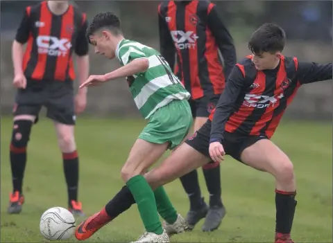  ??  ?? Peter McCartney, Bellurgan gets a touch as James Molloy attempts to keep possession for Trim Celtic.