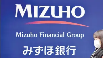  ??  ?? Photo shows a signboard of Japan’s Mizuho Financial Group in Tokyo. Major Japanese bank Mizuho Financial Group is considerin­g slashing its global workforce by about one-third over a decade, reports said, as it looks to replace clerical jobs with...