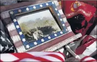  ??  ?? A framed photo of Joe Caldwell, taken near the end of World War II, rests with a tableful of holiday decoration­s at the home of John and Lee Caldwell. Joe, who was John’s father, served in the Marines.