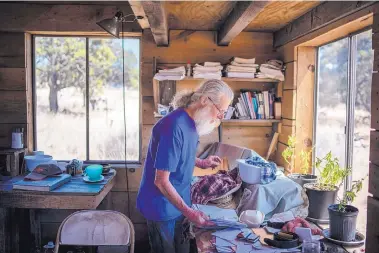  ?? ROBERTO E. ROSALES/JOURNAL ?? Stephen “Uncle River” Kaufman, a Pie Town resident for 12 years, lives about as off-grid as it gets. He has no phone, no internet and no toilet in the small house he built himself. He said he will be hard put to pay the fuel costs of driving just once...