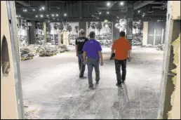  ??  ?? Rick Gibson, right, and Vic Gibson, center, of Dream Themes talk to project manager Darrell Rehagen as they prepare to build a facade for the new attraction Step Right Up.