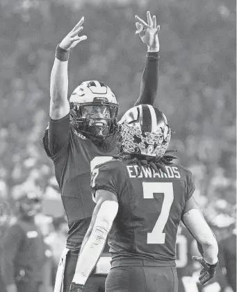  ?? MELANIE MAXWELL/DETROIT FREE PRESS ?? Quarterbac­k J.J. McCarthy celebrates with Michigan running back Donovan Edwards after one of Edwards’ two TD gallops.