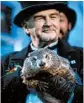  ?? JEFF SWENSEN/GETTY ?? Groundhog handler John Griffiths holds Punxsutawn­ey Phil, who did not see his shadow, predicting an early spring.