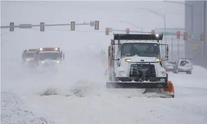  ?? Photograph: Sue Ogrocki/AP ?? Snowplows work during a winter storm in Oklahoma City on 14 February 2021. Oklahoma Natural Gas customers will be paying for the storm for 28 years.