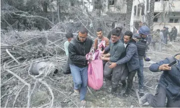  ?? ?? Palestinia­ns transport a victim pulled from the rubble of a family home following Israeli bombardmen­t west of the Nuseirat refugee camp in the central Gaza Strip yesterday. PHOTO: AFP