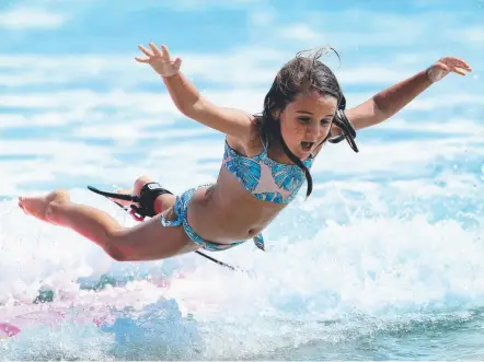  ?? Picture: ADAM HEAD ?? Caitlyn Simms, 5, tries her hand at surfing with her mum at Snapper Rocks yesterday.