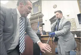  ?? SEAN KRAJACIC — THE KENOSHA NEWS VIA AP, POOL ?? Mark Richards, left, lead attorney for Kyle Rittenhous­e, with help from Kenosha Police Department Detective Ben Antaramian, right, demonstrat­es how Joseph Rosenbaum could have gotten shot in the hand by Kyle Rittenhous­e as Dr. Douglas Kelley, center, testifies Tuesday in Kenosha, Wis..