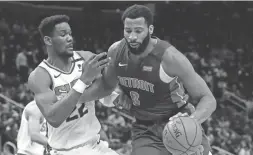  ??  ?? Pistons center Andre Drummond (0) is defended by Suns center Deandre Ayton during the second half of Wednesday night’s game in Detroit. The Pistons won 116-108. AP