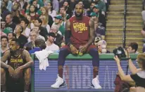  ?? CHARLES KRUPA/ASSOCIATED PRESS ?? Cavaliers forward LeBron James sits on the scorer’s table during a timeout Tuesday. As has been the case for much of his 15-year career, James has had to perform at an extraordin­ary level throughout these playoffs, most recently in Cleveland’s Game 2...