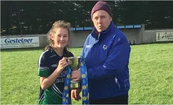  ??  ?? Emma Corcoran Ursuline College captain receives the Connacht Junior cup from Jimmy Murphy of Connacht Council after their win.