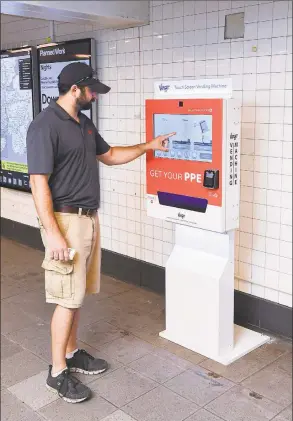  ?? MTA New York City Transit ?? A Metro- North Railroad rider uses a vending machine that dispenses personal protective equipment.