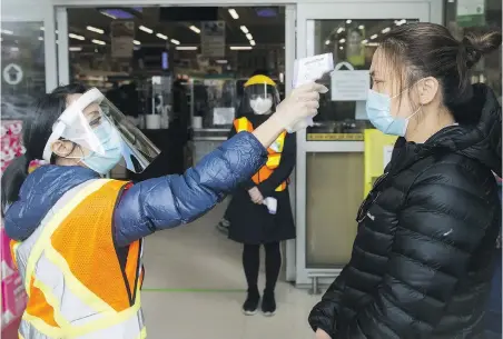  ?? NATHAN DENETTE, THE CANADIAN PRESS ?? People get their temperatur­e tested at T&T Supermarke­t in Markham, Ont., on Monday. Temperatur­e checks and masks are part of increased protective measures companies are using during the pandemic.