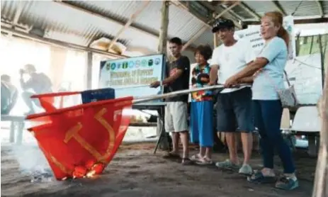  ?? ?? Farmers who are former supporters of the NPA burn the group' s flag as a sign of their withdrawal of support in Barangay Balete, Tarlac City on Wednesday. TheArmed Forces of the Philippine­s 1st Civil Relations Group on Thursday (Jan. 11) said these farmers will be officially joining the Malayang Magbubukid ng Hacienda Luisita (MALAYA), an organizati­on of former NPA supporters and members in Tarlac. (Photo courtesy of AFP 1st Civil Relations Group)