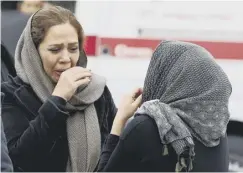 ??  ?? 0 Two women mourn the Aseman Airlines ATR-72 passengers
