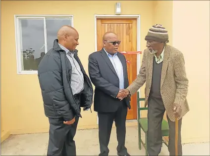  ?? Picture: SUPPLIED ?? NEW HOME: Matotose Dyakalashe, right, who is 82, sick, blind and taken care of by his son and neighbours, received a new RDP house yesterday. It was handed to him by BCM mayor Xola Pakati and speaker Alfred Mtsi. A storm damaged Dyakalashe’s mud home