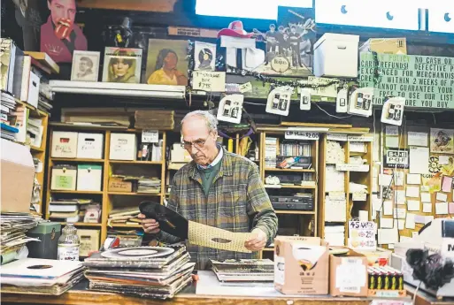  ?? Photos by AAron Ontiveroz, The Denver Post ?? Co-owner Dave Stidman checks out new arrivals at Wax Trax on Oct. 31.