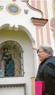  ?? Foto: Hans Bosch ?? Prälat Ludwig Gschwind zeigt auf sein eigenes Wappen an der Mindelzell­er Kirche.