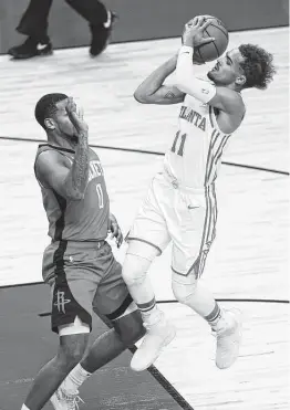  ?? Yi-Chin Lee / Staff photograph­er ?? Rockets guard Sterling Brown, left, gives Hawks guard Trae Young room to operate during the first quarter Tuesday night.