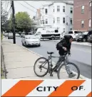  ?? BRIAN SNydER/ REUTERS ?? A youngster walks past authoritie­s gathered Tuesday on a street in Everett, Mass., in connection with a suspect’s slaying by law enforcemen­t officers.