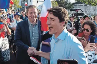  ?? MARC GRANDMAISO­N THE CANADIAN PRESS ?? Then-prime minister Justin Trudeau, centre, greats Conservati­ve Leader Andrew Scheer while walking with the crowd at an event honouring National Acadian Day in August in Dieppe, N.B.
