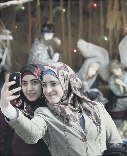  ?? PICTURE: AFP/GETTY ?? 0 Muslim women pose for a selfie outside the Church of the Nativity in Bethlehem