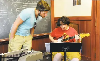  ?? Carol Kaliff / Hearst Connecticu­t Media ?? Guitar instructor Andrew Lipow spends time with Ben Stevens, of New Milford, at the Litchfield Jazz Camp in 2014.