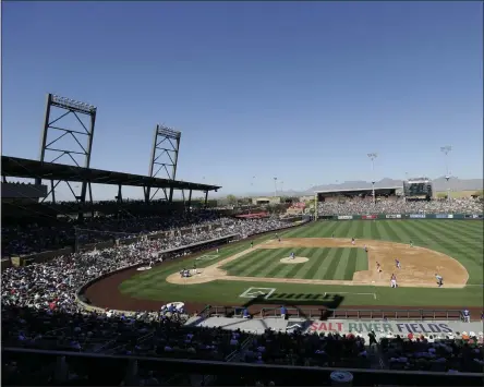  ?? JEFF CHIU - THE ASSOCIATED PRESS ?? FILE - In this March 18, 2016, file photo, fans at Salt River Fields at Talking Stick watch a spring training baseball game between the Arizona Diamondbac­ks and the Los Angeles Dodgers in Scottsdale, Ariz. The Diamondbac­ks sold out their entire spring allotment of tickets in less than 24 hours after they went on sale to the public. Approximat­ely 2,200 tickets were sold for all 14 of the team’s home games, with fans spread throughout the park in pods of two, four or six seats and masks are required except when eating or drinking.